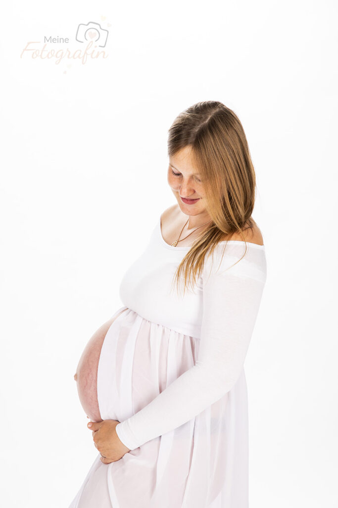 Babybauchfoto vor weißem Hintergrund