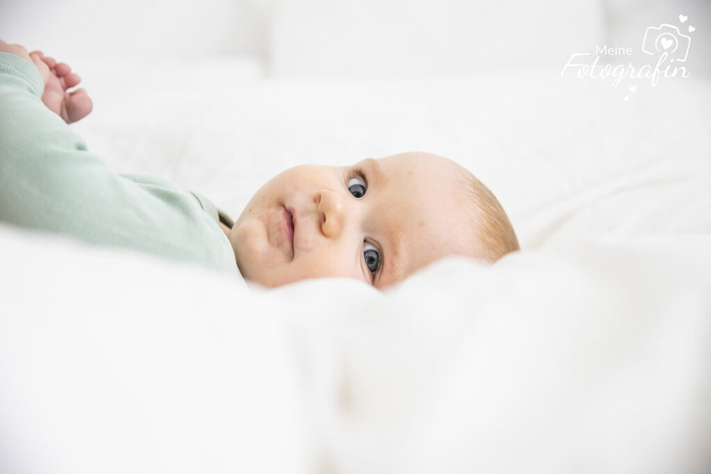 Baby liegt am Bett