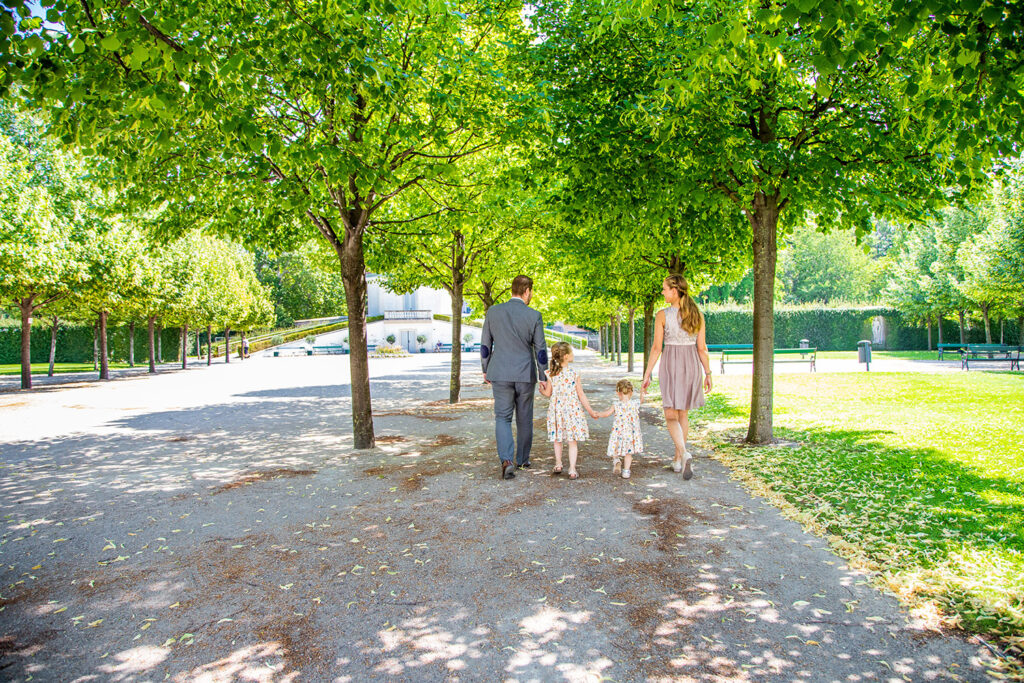 Familie geht zu viert im Grünen